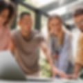 Jeunes professionnels divers collaborent avec enthousiasme autour d'un ordinateur portable et documents.