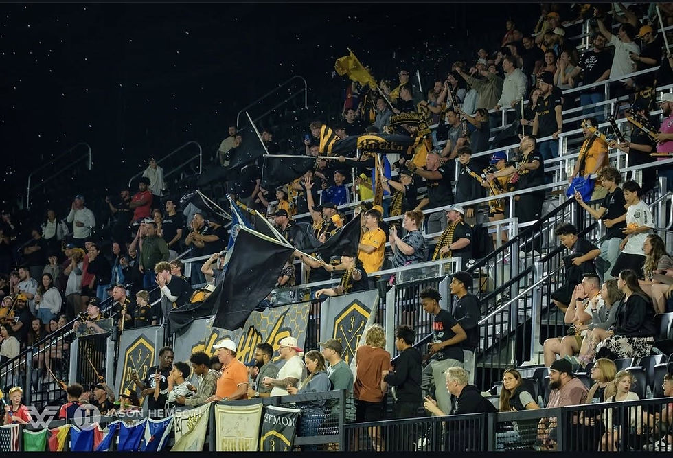 Photo of fans  in a stadium watching a soccer match.