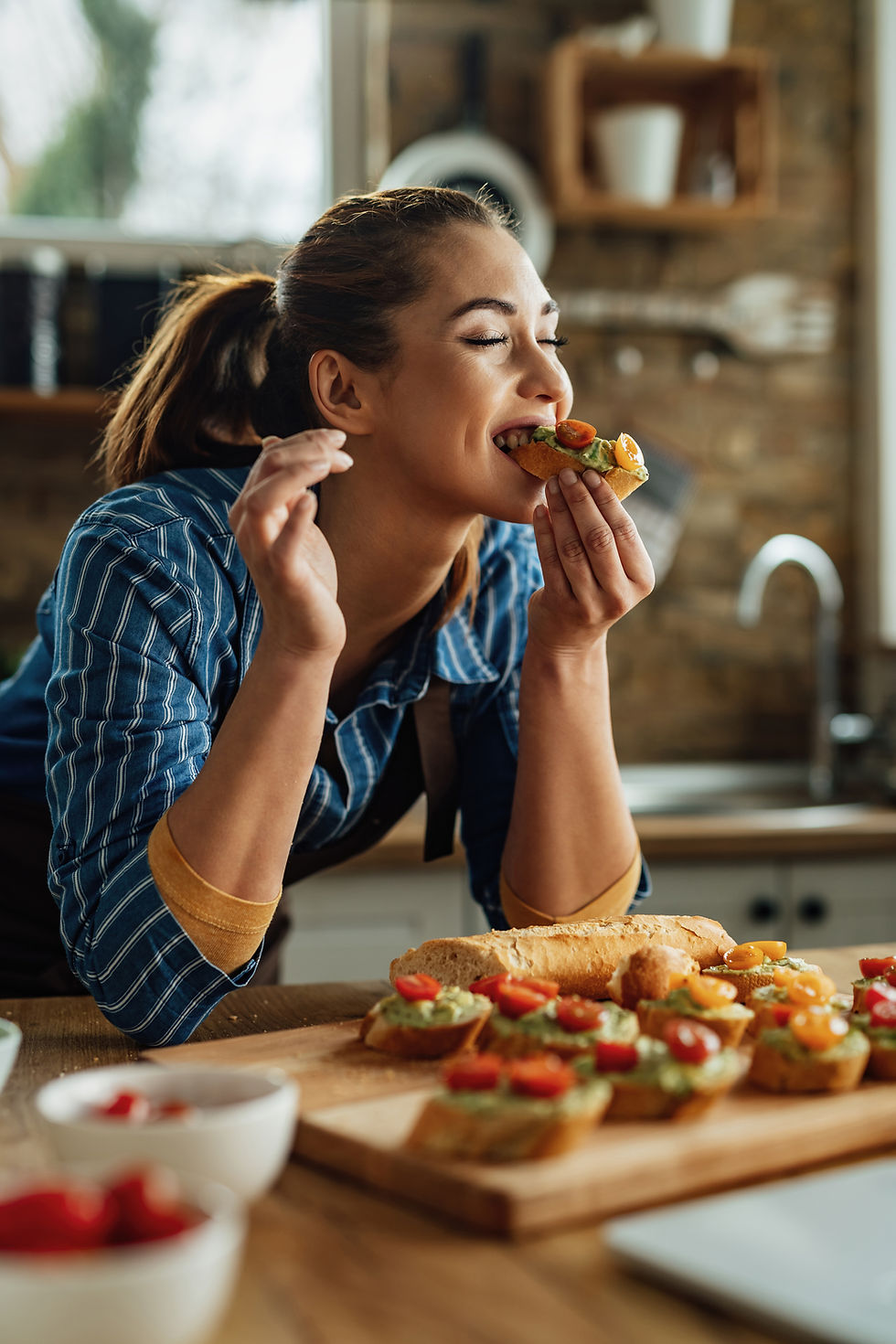 young-woman-enjoying-taste-healthy-bruschetta-with-her-eyes-closed-kitchen.jpg