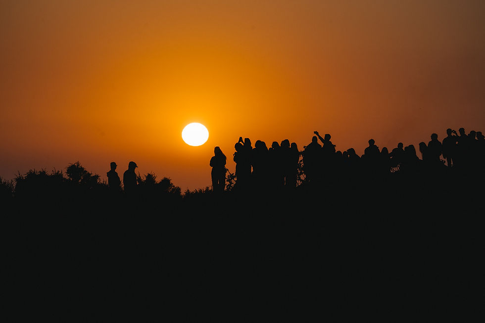 crowd watching the sunset in Taghazout and taking photos