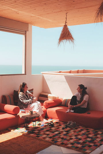 Two guests haging out at the sunny lounge with ocean view. Perfect spot for work breaks and socializing