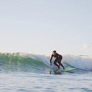 Surfer with equipment riding a green wave