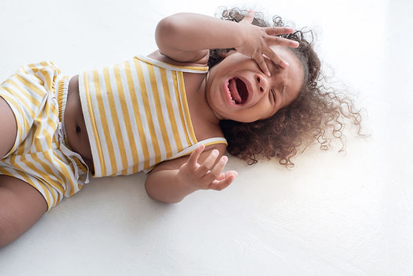 child girl crying and shouting with tantrum lying on the floor at home.jpg