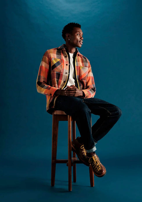 Male model wearing a Wax London's Premium Overshirt sitting on stool