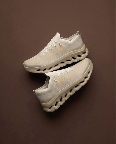 On Cloudtilt Moon Sneakers laying flat on a brown background at Evolve Clothing Gallery New Jersey