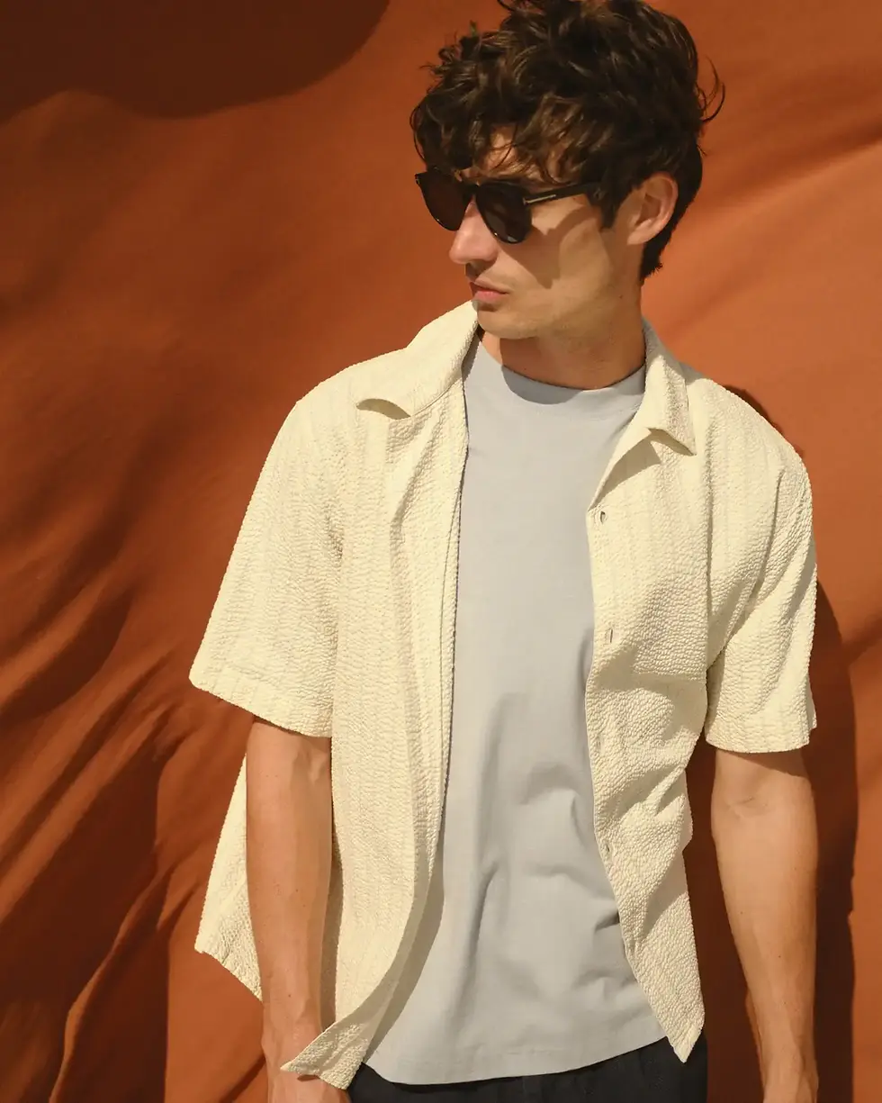 Thumbnail: Male model wearing the Wax London Didcot Seersucker Stripe Shirt in ecru and blue in studio