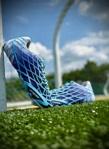 Adidas Bad Bunny F50 Ghost Sprint Sneakers lean on a soccer goal post