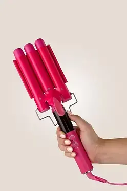Thumbnail: Luxe + Willow Triple Barrel Waver in pink held in hand for glossy frizz-free beach wave styling.