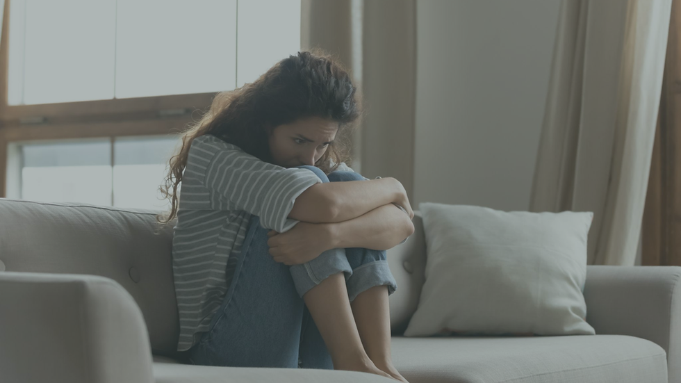 Woman sitting alone by a window looking emotionally drained and reflective after a difficult relationship experience.