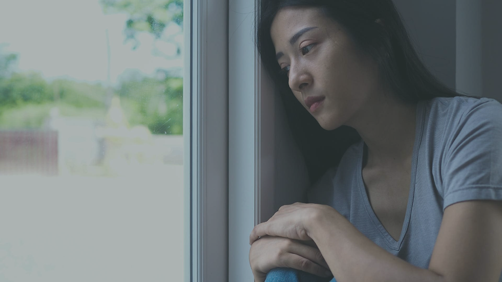 Person sitting alone feeling emotionally exhausted, disconnected, and uncertain about their sense of self.