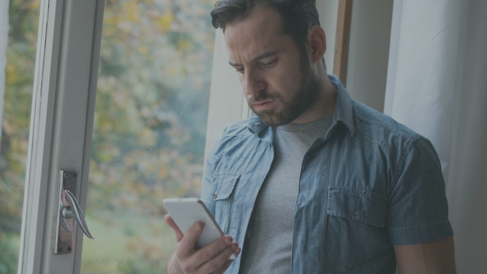 Person checking their phone while experiencing uncertainty in a relationship