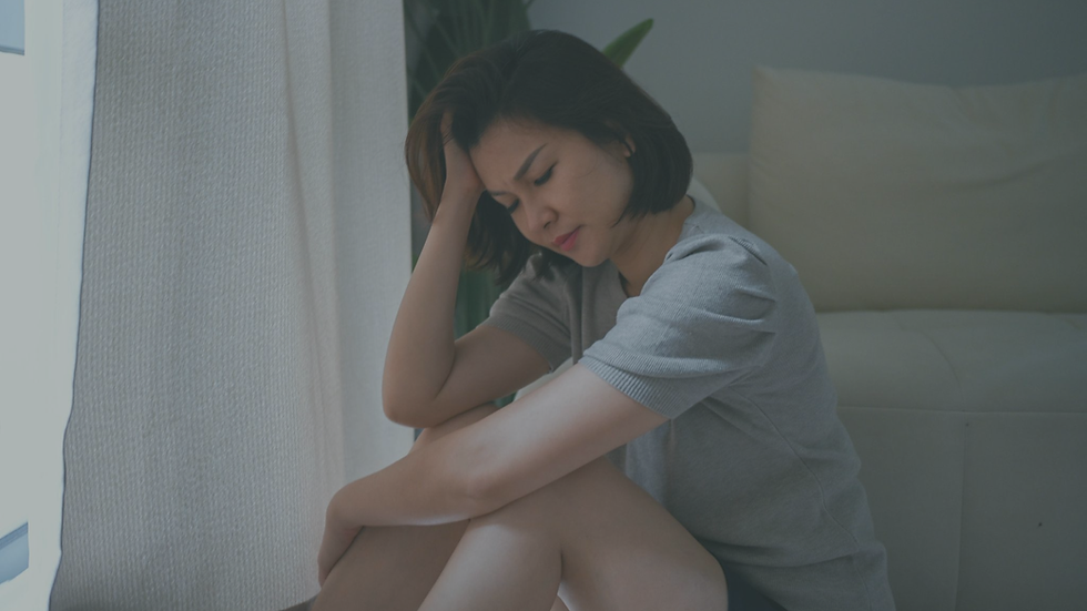 Person experiencing physical stress symptoms such as fatigue, tension, and headaches while sitting quietly at home.