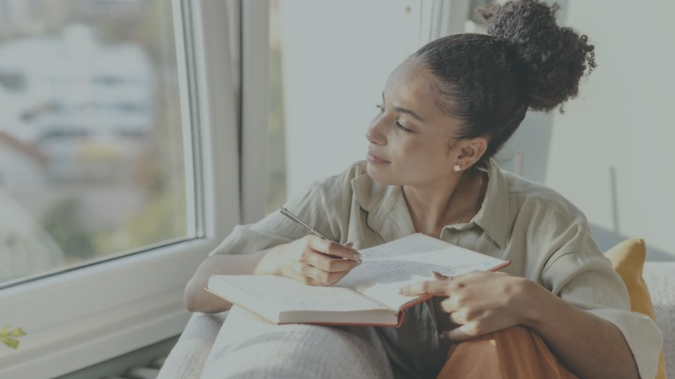 Person reflecting and journaling about stress, burnout, and emotional wellbeing.
