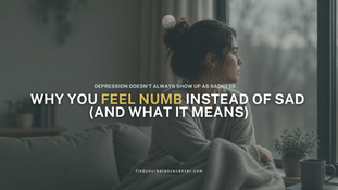 Woman sitting quietly by a window in a dimly lit room, reflecting on emotional numbness and depression symptoms.