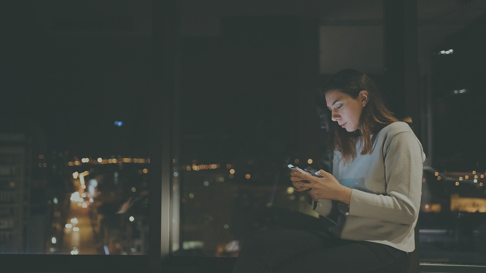 Teen girl using her phone at night in bed with a worried expression, showing how social media use can contribute to anxiety and emotional stress