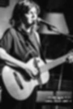 Chanteuse à la guitare lors des concerts 2023 à La Boîte à Meuh