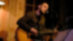 Chanteur guitariste sur scène pour les concerts 2023 à La Boîte à Meuh.
