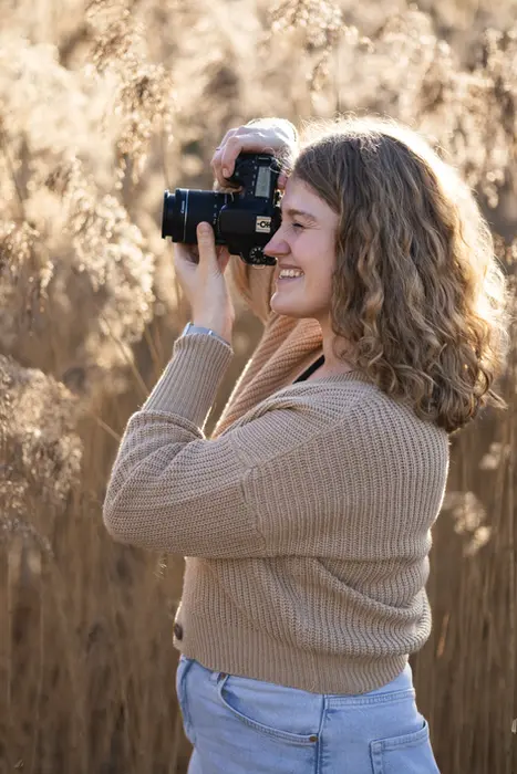 Fotograf fotografiert und man sieht sie seitlich im Profil vor einem Feld. 