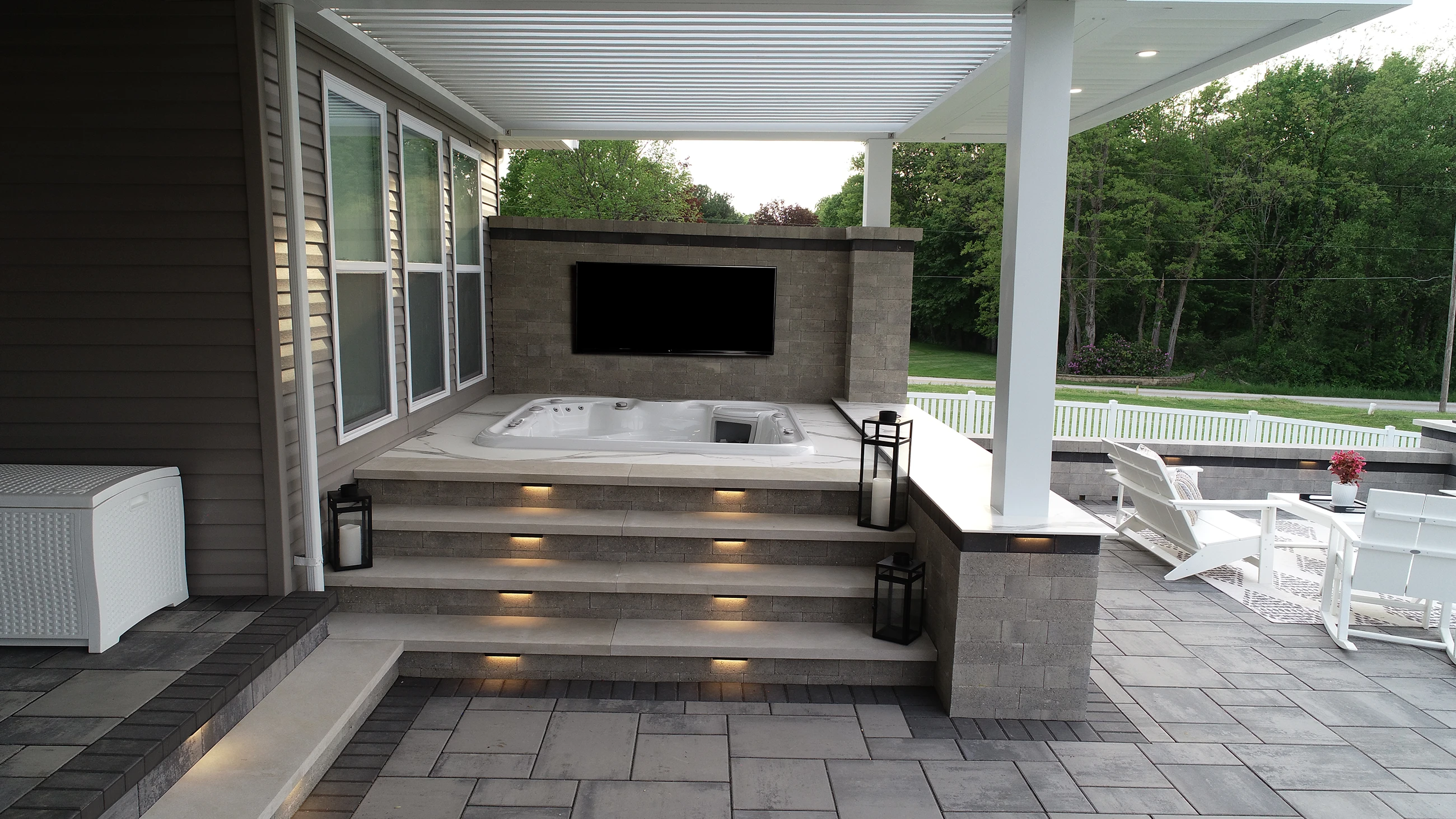 Luxury backyard spa patio with step lighting under a motorized pergola installed by Allscape Patio in Wadsworth, Ohio.