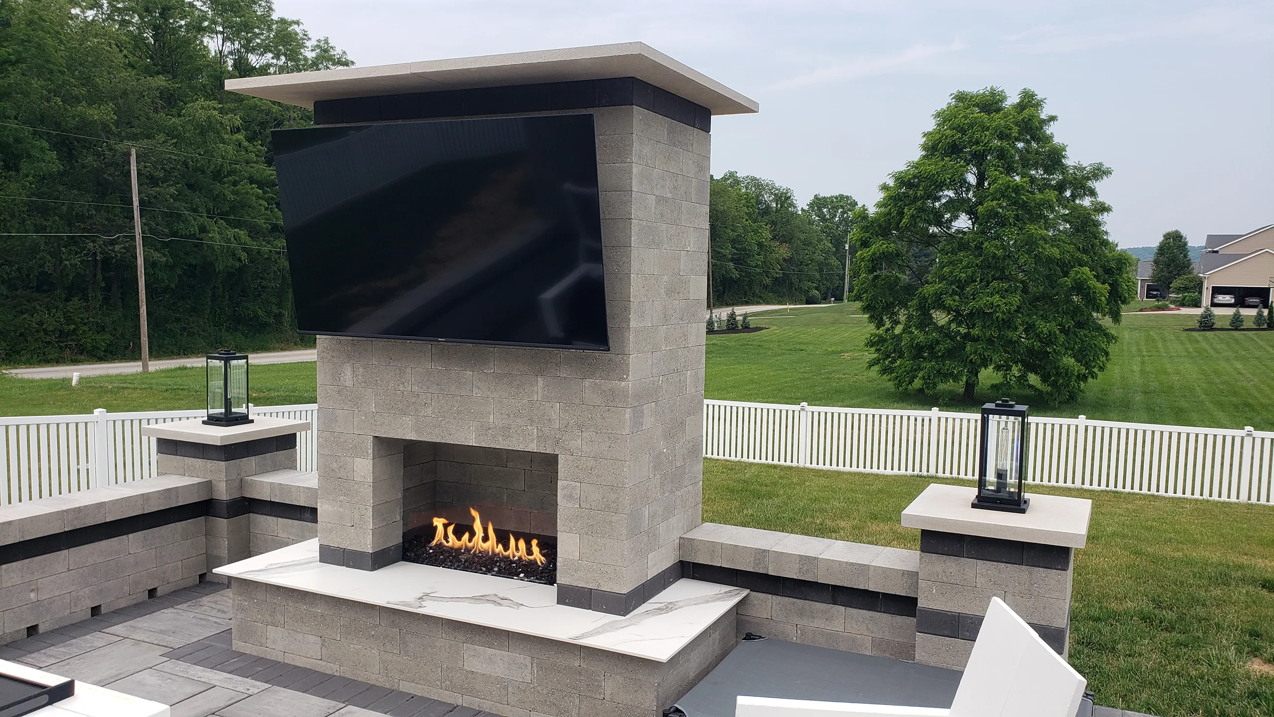 Luxury outdoor fireplace and television entertainment wall on a custom patio installed by Allscape Patio in Wadsworth, Ohio.