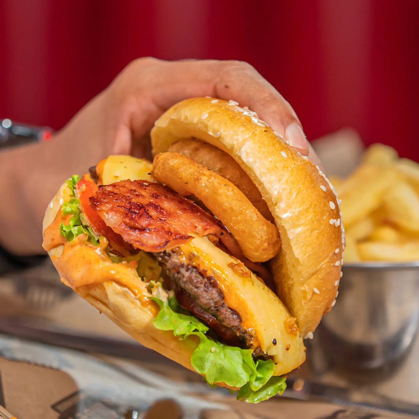 Pure burger bliss! A juicy beef burger stacked with lettuce, cheese, rashers, and crispy onion rings, all tucked in a seeded brioche bun and served with golden chips.
