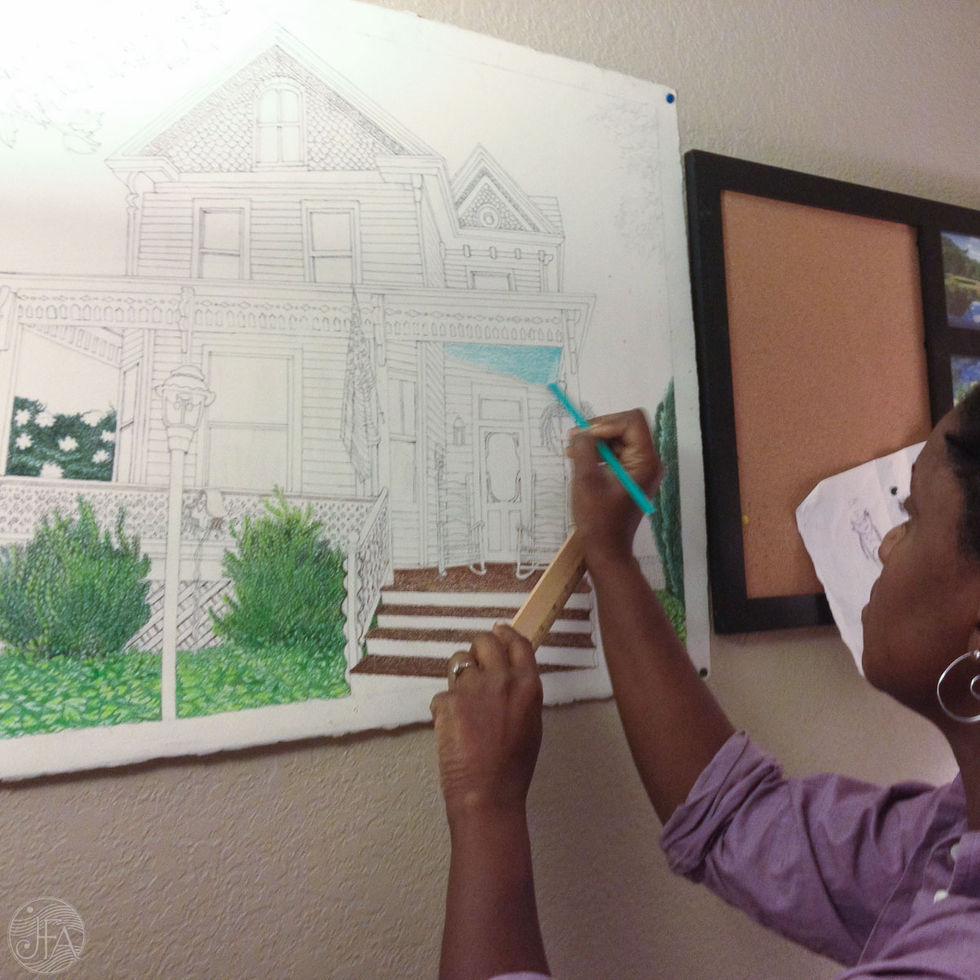 Artist inking Cape May house architectural drawing on wall-mounted paper.