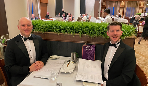 Tom and Dom enjoying a five-course dinner at a table for two in the Buckingham Restaurant on formal night aboard Ambassador Ambience.