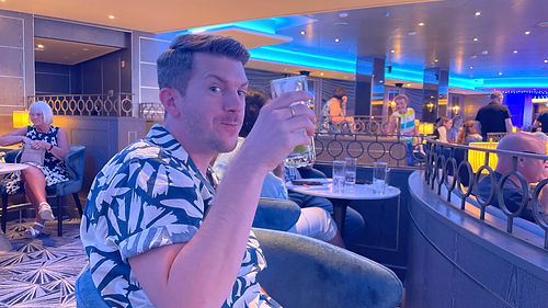 Tom enjoying a drink included in the Princess Plus package inside the Princess Live venue aboard Sky Princess.