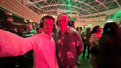 Cruise content creators Tom and Dom wearing glowing headphones at a silent disco inside the SkyDome on P&O Iona.