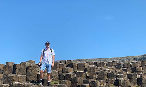 Dom from Tom and Dom Travel walking on the Giant’s Causeway in Northern Ireland