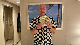 Dom celebrating a lucky win with dollar bills in the casino aboard Enchanted Princess.