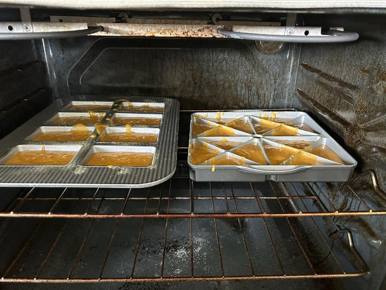 Two pans of brownies baking in oven