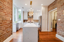 Gordon Townhouse Savannah modern kitchen with marble island and exposed brick by Savannah Stays