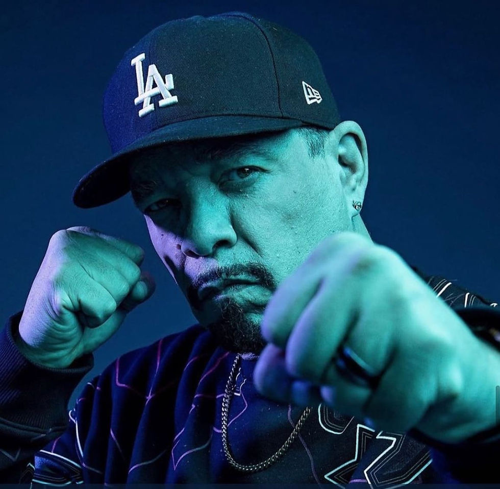 Das Bild zeigt Rapper Ice-T mit einem schwarzen Pullover und einem schwarzen Basecap mit dem Aufdruck LA. Seine Fäuste hält er wie ein Boxer vor und neben dem Gesicht.