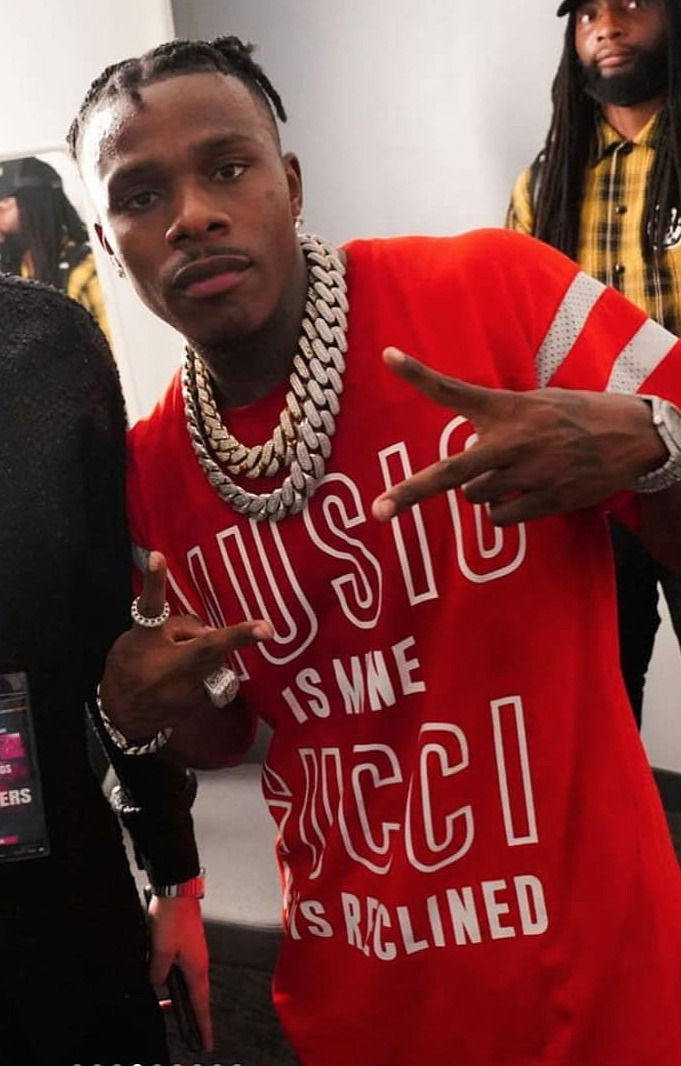 Das Bild zeigt den Rapper DaBaby mit einem roten T-Shirt und eine dicke Silberkette um den Hals