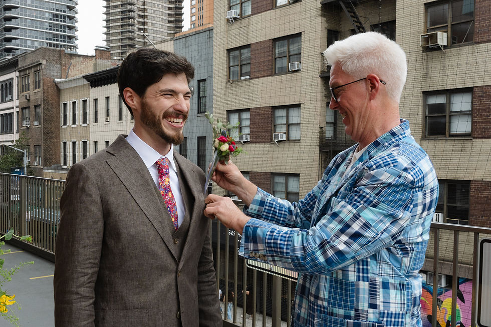 groom laughing while getting boutonniere