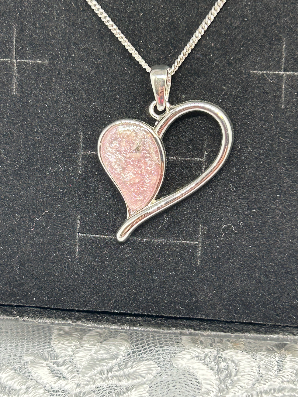 Thumbnail: Sterling Silver half filled heart necklace featuring a pink inclusion stone with partially visible ashes