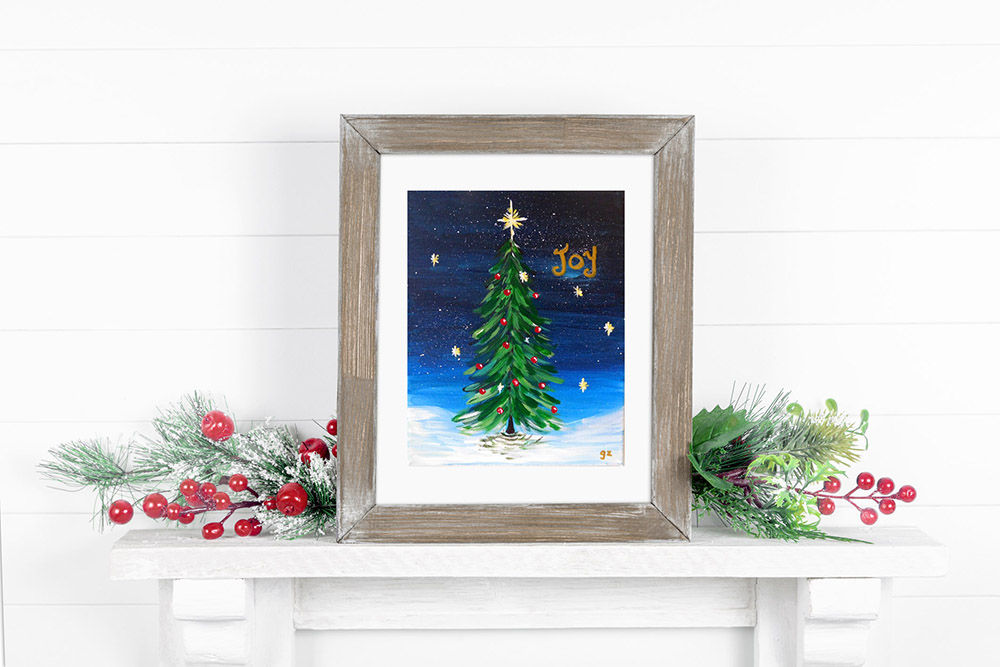 Joy Christmas Tree print framed on a fireplace decorated for the holidays