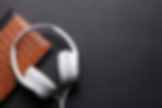 White Headphones resting on a black tabletop