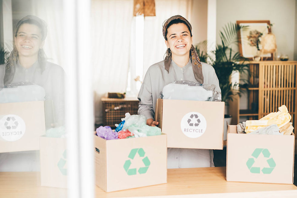 woman holding recycling boxes for a charity shop while smiling.