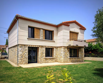 Maison de maître rénovée, intégrant une juxtaposition harmonieuse entre la pierre naturelle et un enduit contemporain. Le soubassement en pierre offre une assise visuelle solide et traditionnelle, tandis que les étages supérieurs sont recouverts d'un enduit lisse, créant un contraste moderne. Les ouvertures généreuses, associées aux volets en bois, accentuent l'aspect chaleureux et authentique de la bâtisse. Les balcons subtils ajoutent un caractère supplémentaire à cette rénovation soignée, s'intégrant parfaitement dans son environnement verdoyant et offrant un cadre de vie spacieux et élégant