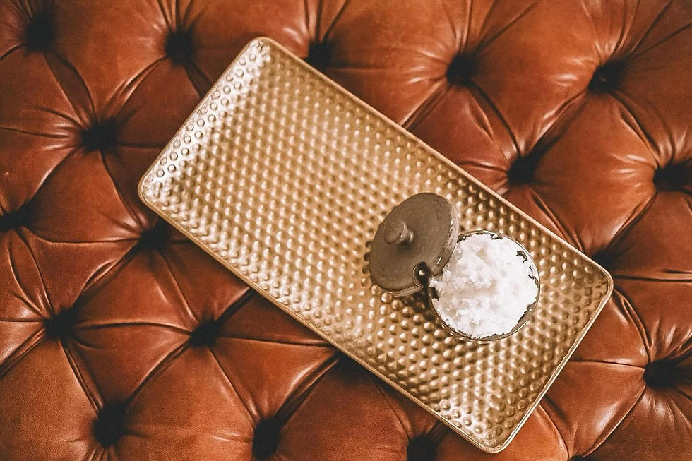 Jar of whipped tallow on gold plate on a leather stool.