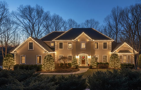 large 2 story stucco house with soft white christmas lights on rooflines and windows.jpg