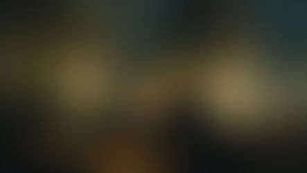 Persona sola in un caffè notturno davanti a una grande vetrata con luci urbane sfocate, immagine simbolica della solitudine contemporanea.