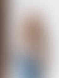 a photographer wearing a camera harness with 2 cameras and smiling at the camera in a seattle studio