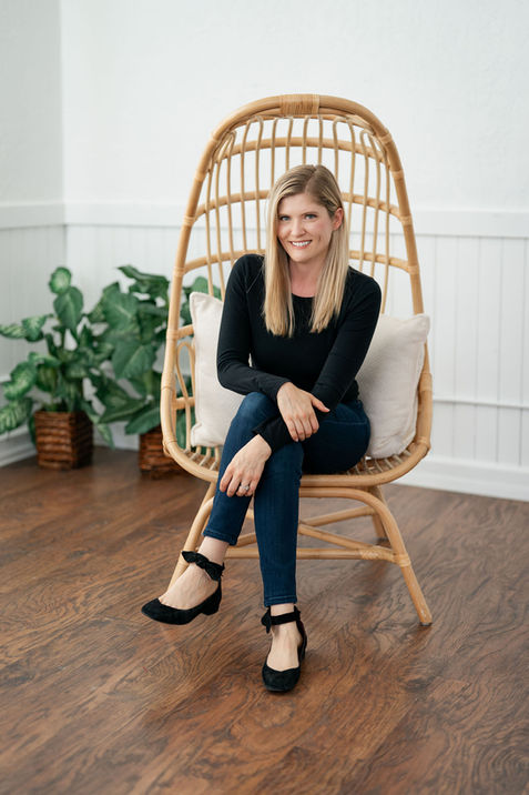 Wellness entrepreneur seated in rattan chair for lifestyle brand session