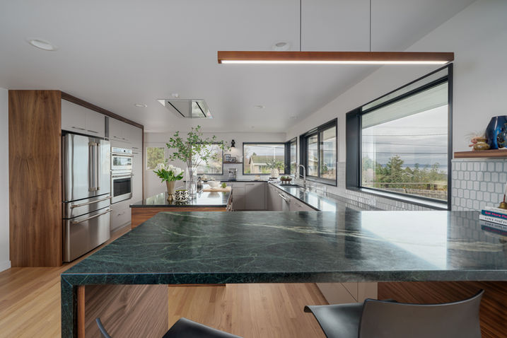Kitchen with long island, bar stools, and large windows