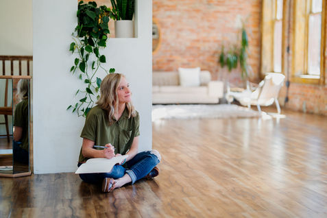 Wellness professional sitting on studio floor during Seattle brand session