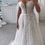 Thumbnail: Woman wearing an off-shoulder white wedding dress, Chosen by Khya, Orelle. Elegant bridal gown.