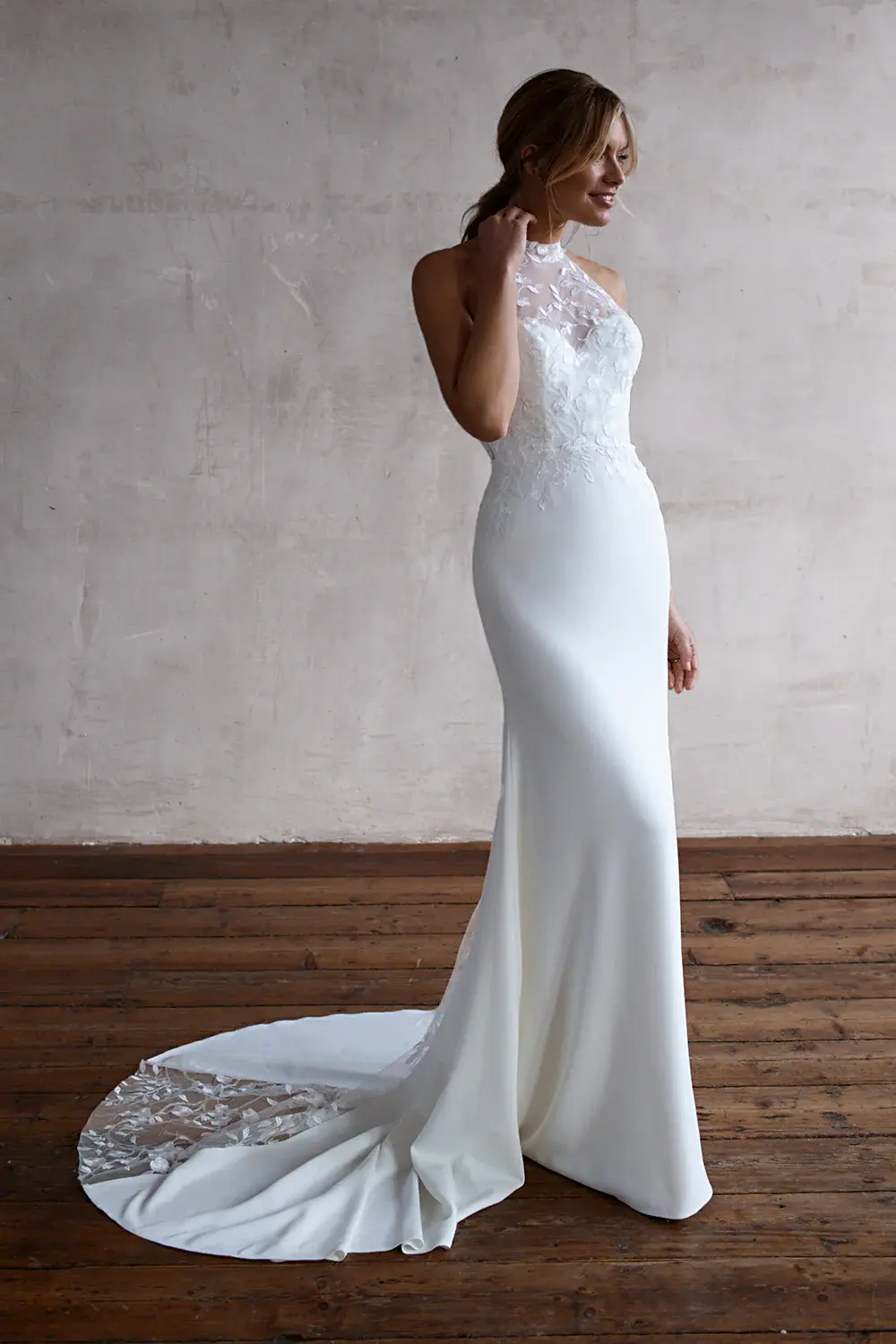 Elegant bride poses in white wedding dress with Bow Two Tier Veil andsheloves.